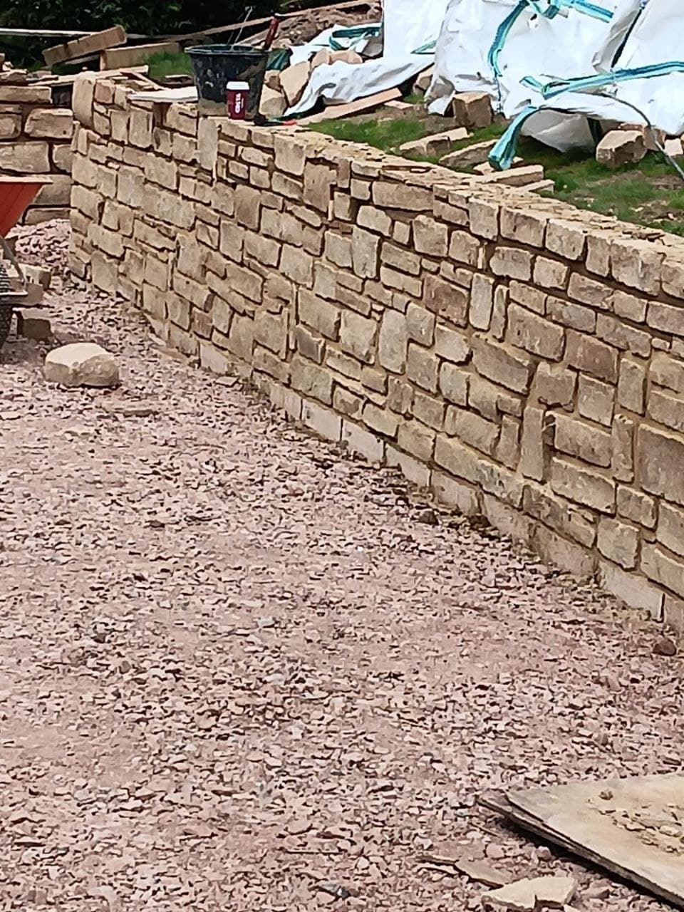 Hand-built natural dry-stone wall in warm Sussex sandstone